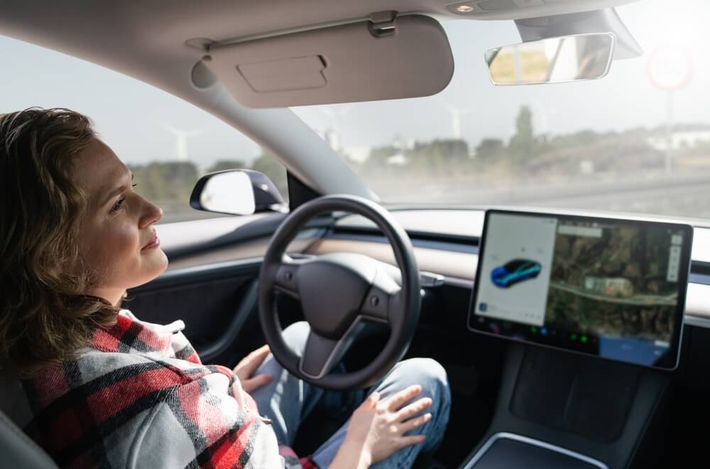Woman resting while her car is driven by an autopilot. Self driving vehicle.
