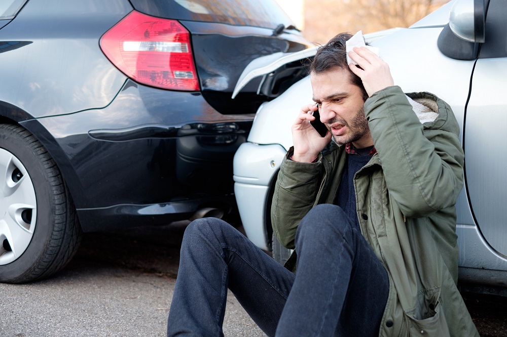 Injured driver feeling pain on his head from car accident.