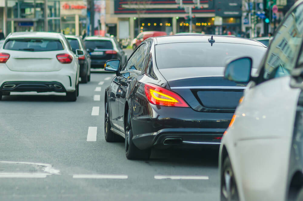 Black car signaling to the left to change lane.