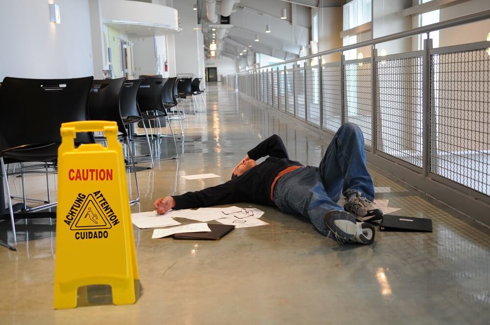 Worker slip and fall in the hallway due to wet floor.