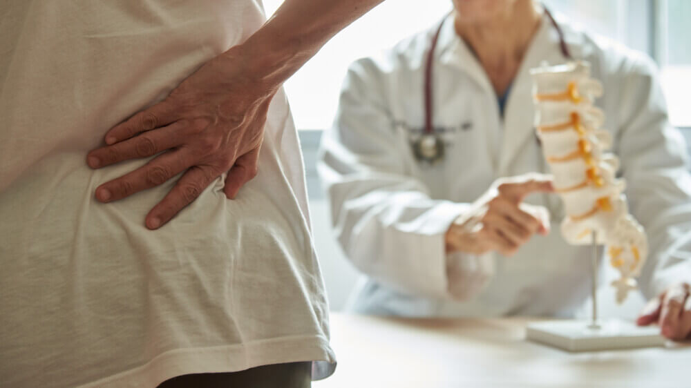 Man suffering back pain consulting doctor.