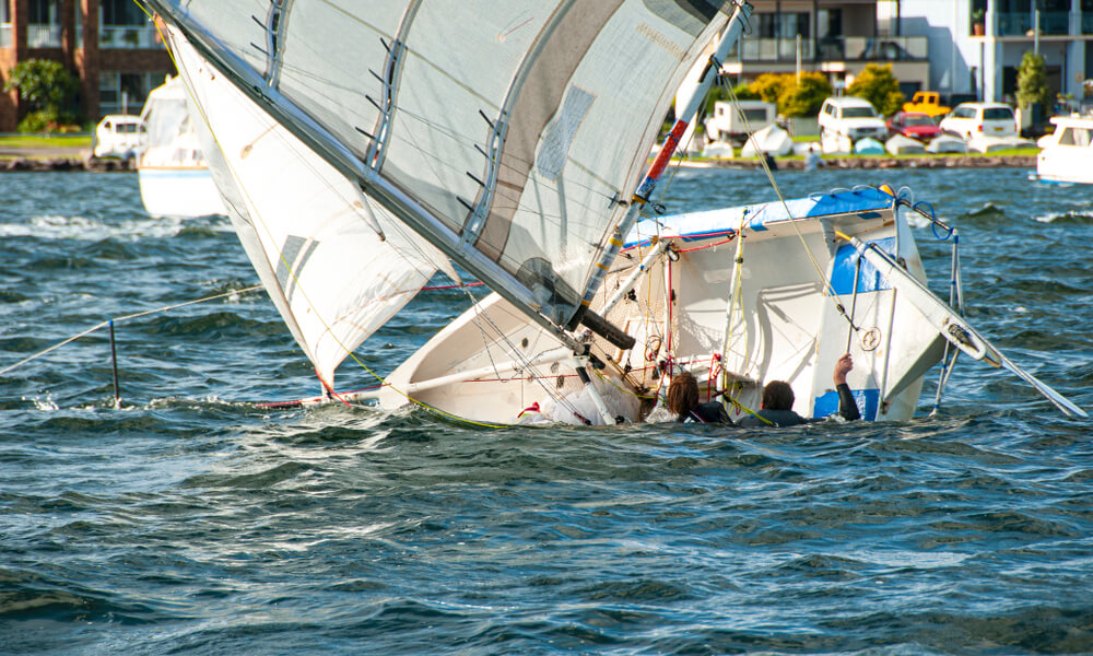 White sailboat sinking accident near the port.