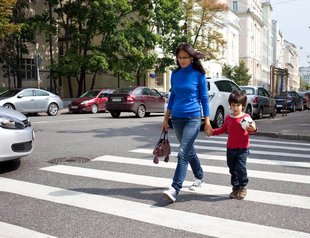 Mother and kid crossing the pedestrian lane.