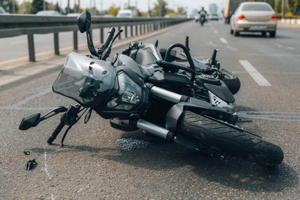 Motorcycle fell down in the street from accident.
