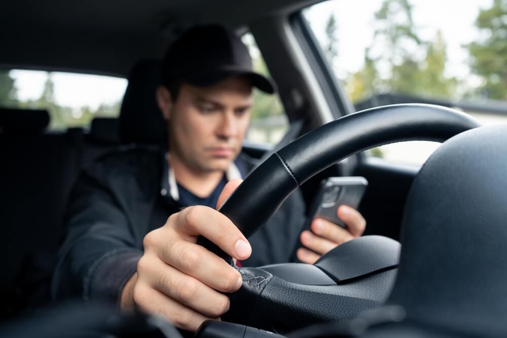 Driving car and using phone to text.