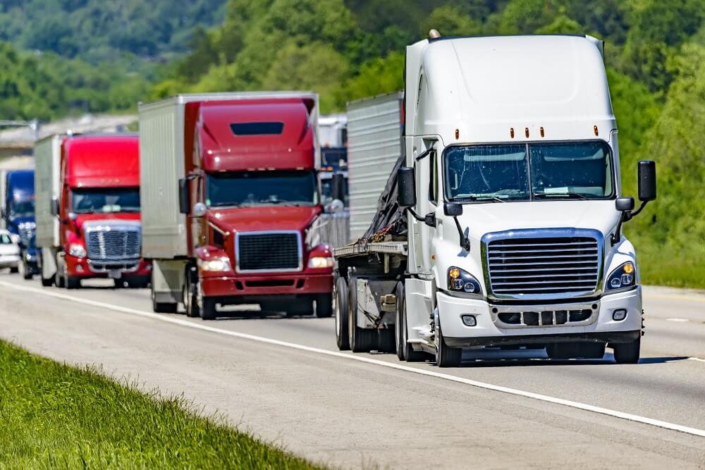 Trucks in group passing interstate.