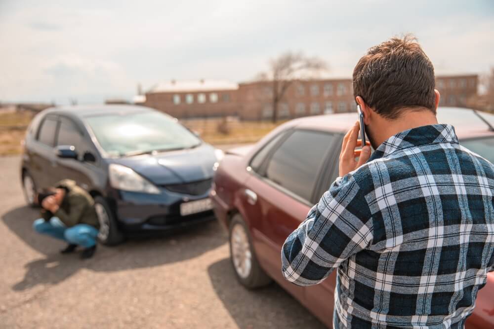 Drivers involved in car accident calling their respective insurance.